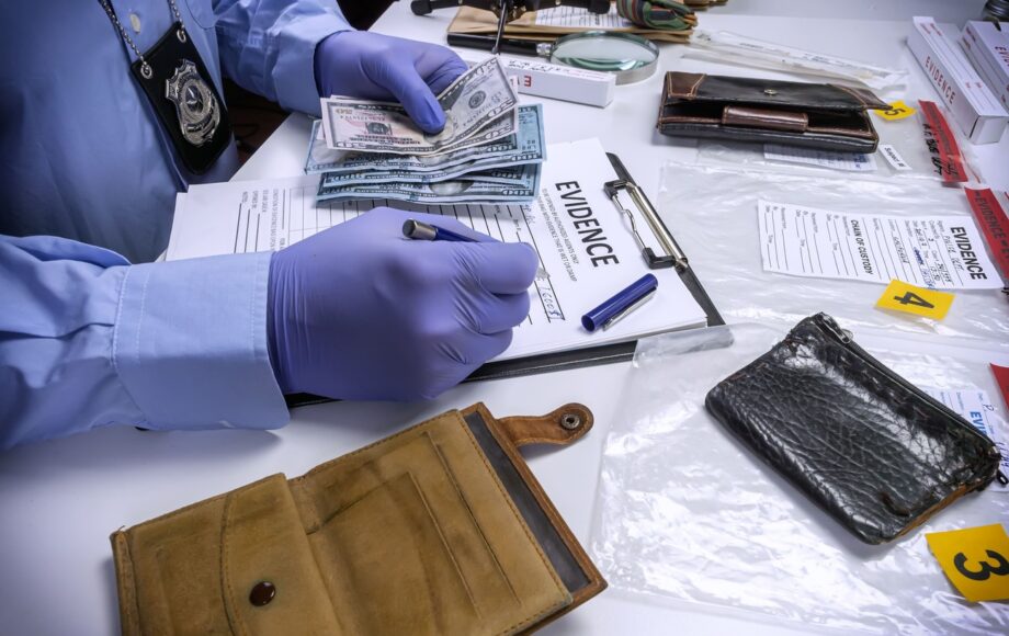Law enforcement officer counting cash as drug crime evidence representing Dallas drug charges defense cases