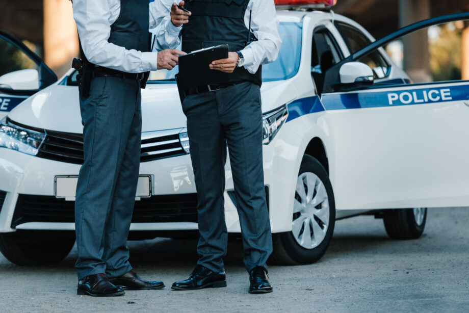 Dallas police officers documenting a commercial truck accident scene with patrol vehicle and clipboard report