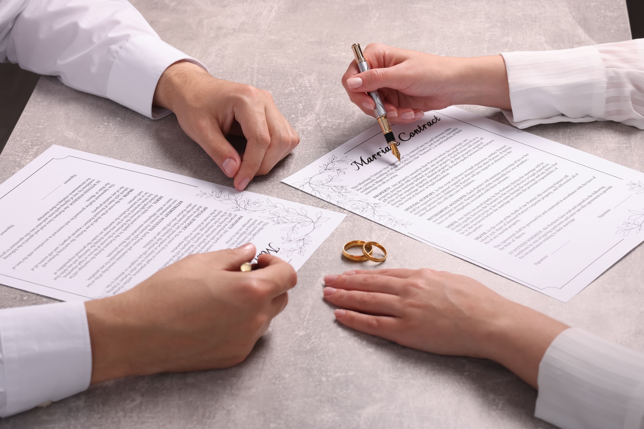 Wedding rings placed on a premarital agreement document