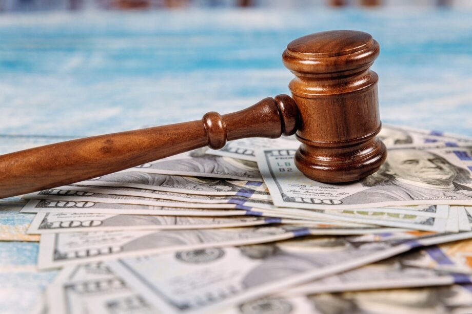 A judge's gavel resting on spread US hundred dollar bills representing compensation and settlement calculation in a Texas truck accident lawsuit