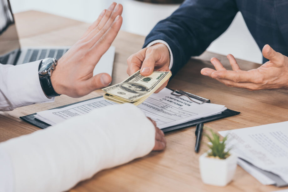 Injured person refusing cash settlement offer from insurance adjuster over a truck accident claim, highlighting dispute over fair compensation in Texas