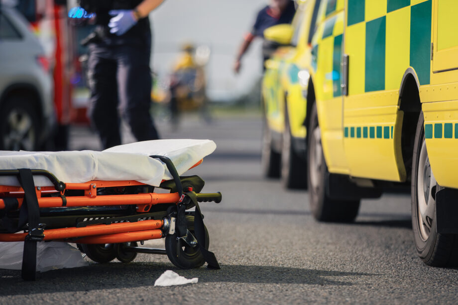 Emergency responders preparing a stretcher after a serious truck accident in Texas with ambulance and police at the scene