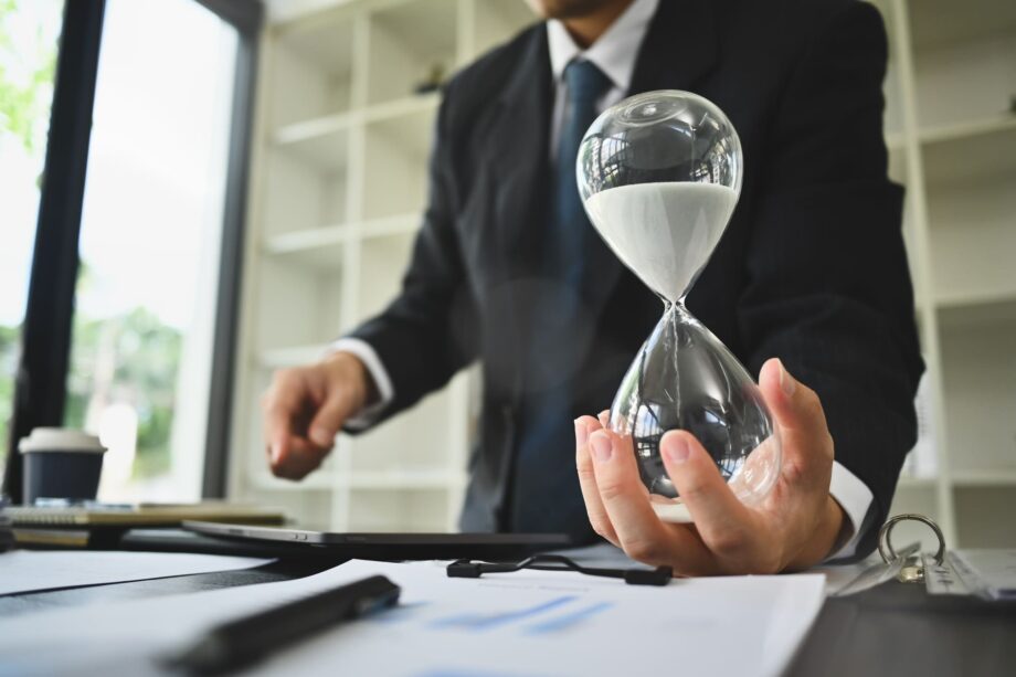 A suited professional holding an hourglass over legal documents representing the two-year wrongful death statute of limitations deadline under Texas law